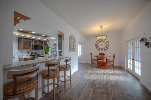 kitchen with stainless steel appliances, a wealth of natural light, dark wood finished floors, and baseboards