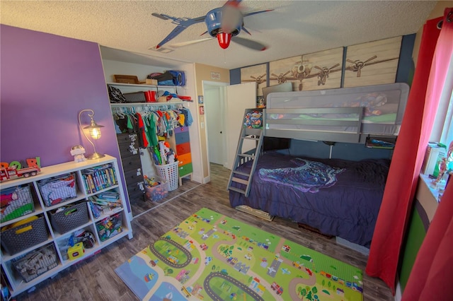 bedroom featuring a closet, ceiling fan, a textured ceiling, and wood finished floors