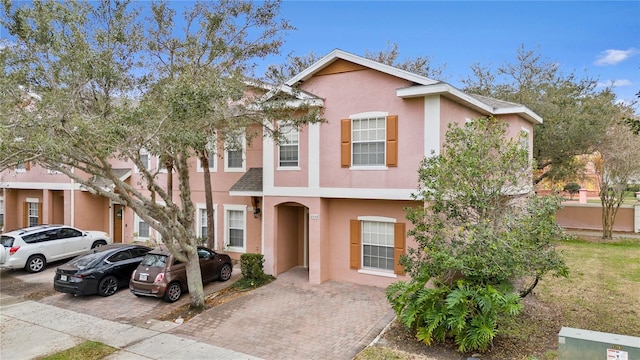 multi unit property with decorative driveway and stucco siding