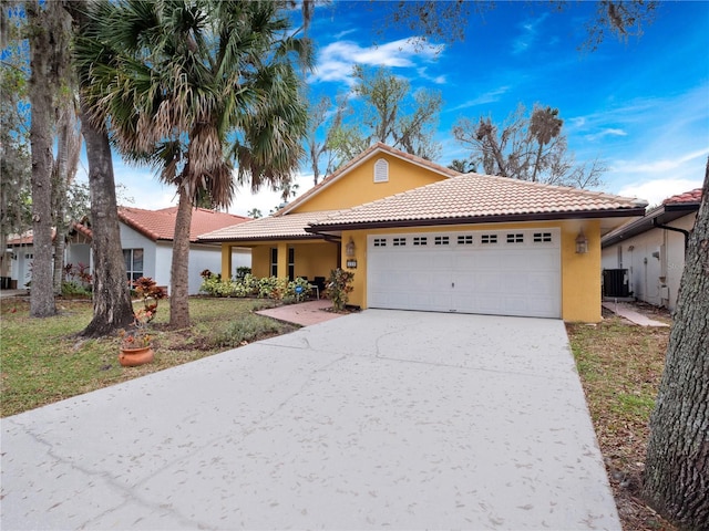 view of front of property featuring a garage, driveway, central AC unit, a tile roof, and stucco siding