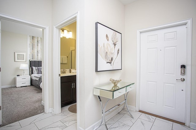 foyer featuring marble finish floor and baseboards