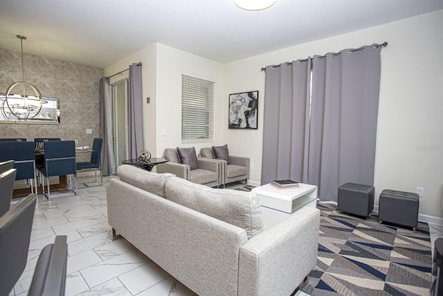 living area featuring baseboards, marble finish floor, and an inviting chandelier