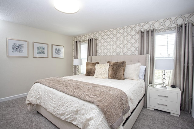 bedroom featuring baseboards, multiple windows, carpet, and wallpapered walls