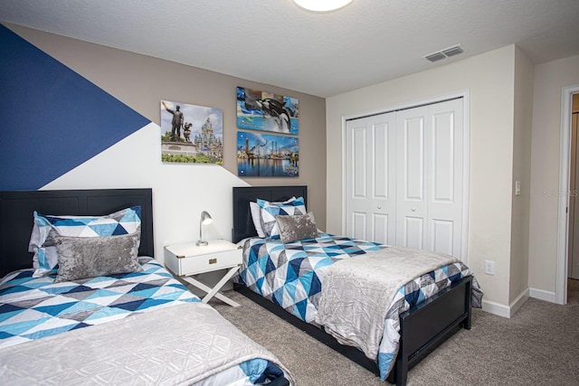bedroom featuring a textured ceiling, carpet flooring, visible vents, baseboards, and a closet