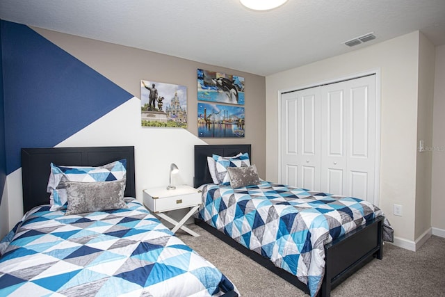 carpeted bedroom featuring a closet, visible vents, a textured ceiling, and baseboards