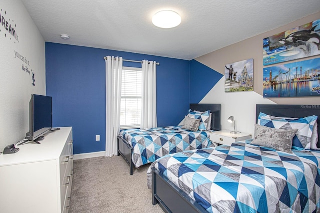 bedroom featuring light colored carpet, a textured ceiling, and baseboards