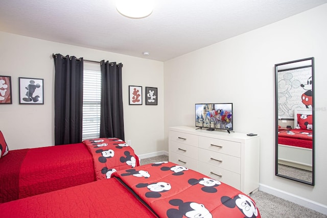 bedroom featuring light carpet, a textured ceiling, and baseboards