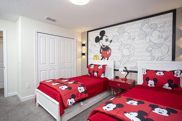 carpeted bedroom featuring a closet, visible vents, a textured ceiling, and baseboards