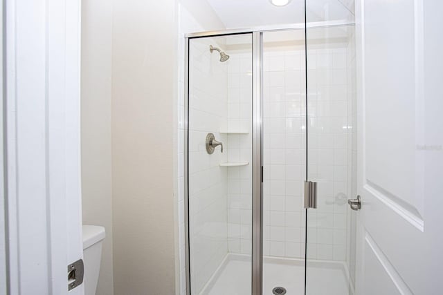 full bath with a stall shower and toilet