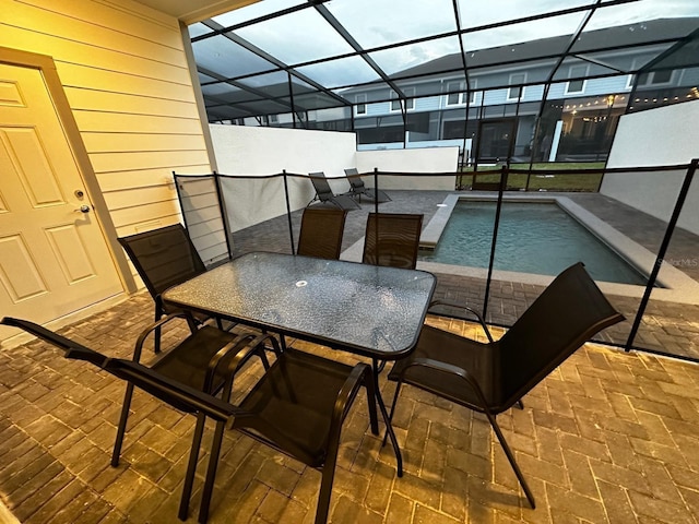 view of patio / terrace with outdoor dining area, an outdoor pool, and a lanai