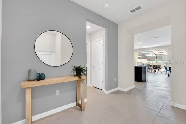 hall featuring visible vents and baseboards