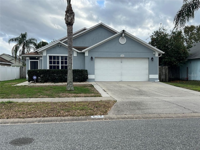 ranch-style house with concrete driveway, an attached garage, fence, and stucco siding