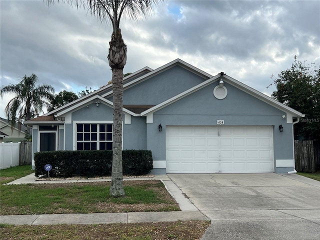 single story home with an attached garage, fence, and stucco siding