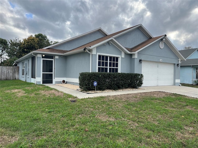 ranch-style home featuring an attached garage, fence, concrete driveway, stucco siding, and a front yard