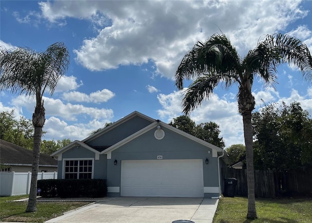 single story home with concrete driveway, an attached garage, fence, and stucco siding