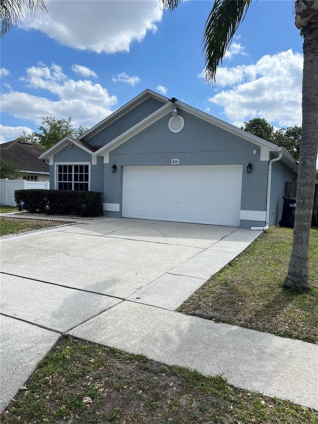 view of front of property with stucco siding, an attached garage, and driveway