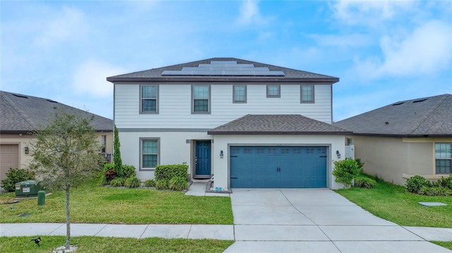 view of front of house featuring a shingled roof, concrete driveway, roof mounted solar panels, a garage, and a front lawn