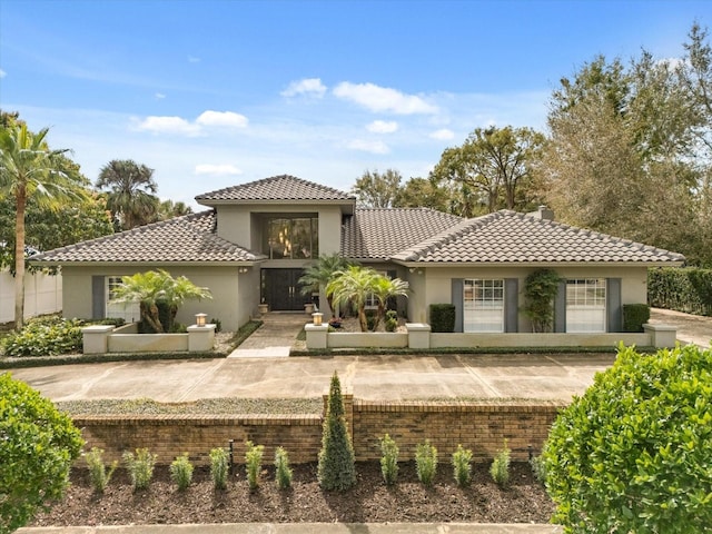 mediterranean / spanish-style home featuring a tile roof and stucco siding