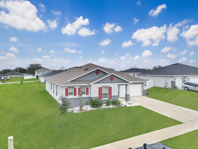 view of front of house with concrete driveway, a front lawn, board and batten siding, and roof with shingles