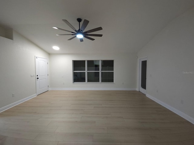 unfurnished room featuring lofted ceiling, light wood-type flooring, baseboards, and ceiling fan