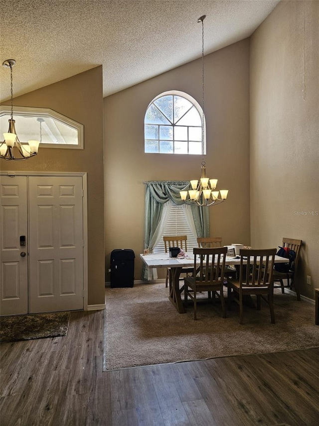 entryway with dark wood-style floors, high vaulted ceiling, and an inviting chandelier