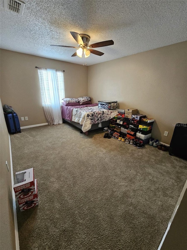 bedroom with a textured ceiling, carpet flooring, visible vents, and a ceiling fan