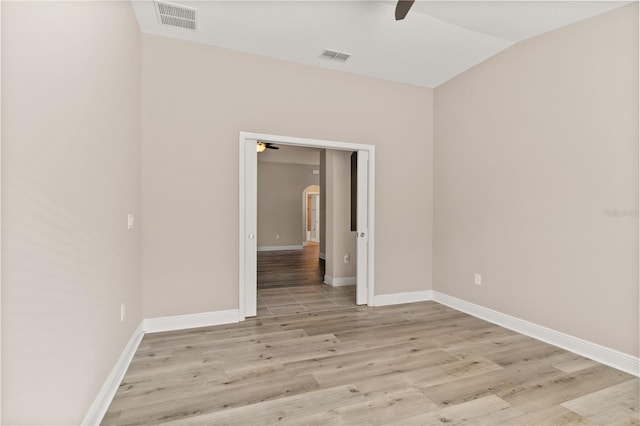 unfurnished room featuring lofted ceiling, visible vents, ceiling fan, and light wood-style flooring