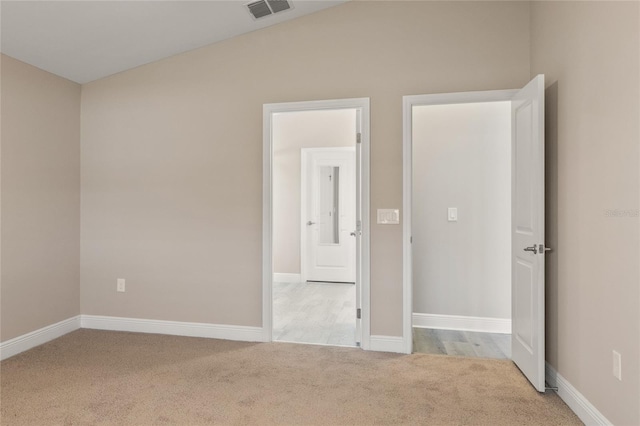 interior space with light carpet, baseboards, and visible vents