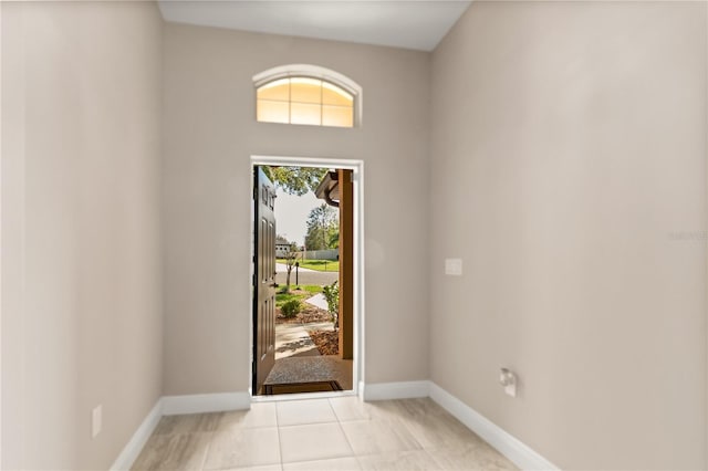 entryway with light tile patterned floors and baseboards