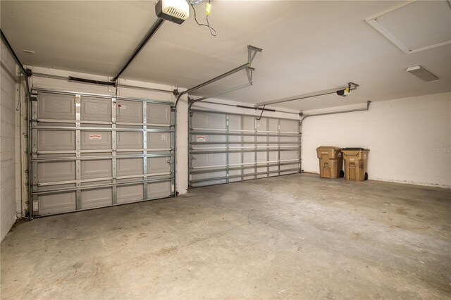 garage featuring concrete block wall and a garage door opener