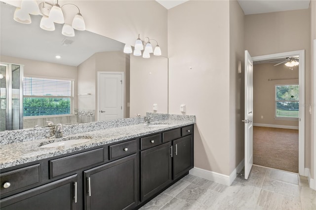 bathroom with a healthy amount of sunlight, double vanity, baseboards, and a sink