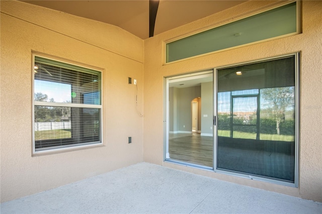 doorway to property featuring a patio area and stucco siding