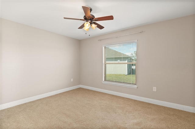 empty room featuring ceiling fan, baseboards, and light colored carpet