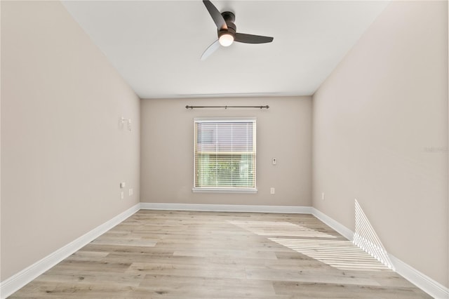 unfurnished room with a ceiling fan, light wood-type flooring, and baseboards