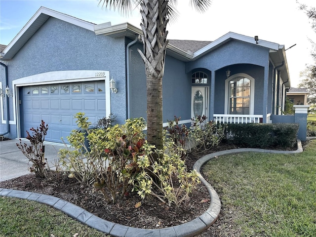 12209 Putter Green Ct, New Port Richey, FL 34654 - view of front of home featuring stucco siding, an attached garage, a porch, and concrete driveway
