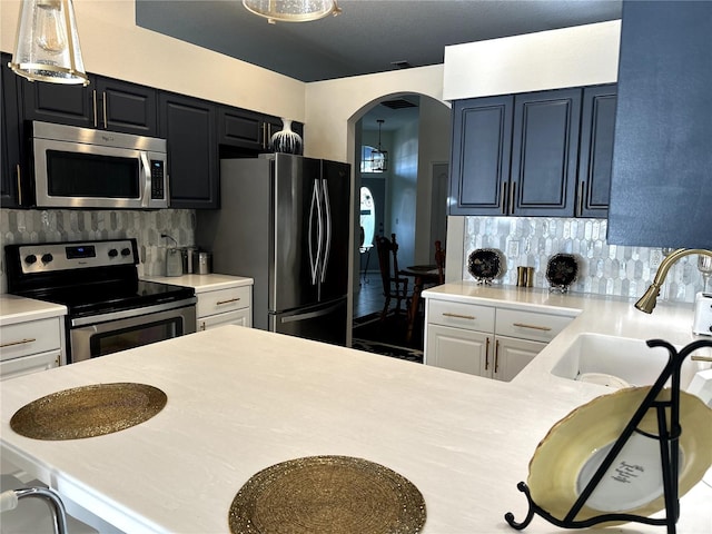 12209 Putter Green Ct, New Port Richey, FL 34654 - kitchen with stainless steel appliances, a sink, light countertops, and arched walkways