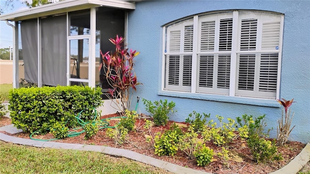 12209 Putter Green Ct, New Port Richey, FL 34654 - view of property exterior with stucco siding and a sunroom