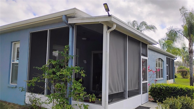 12209 Putter Green Ct, New Port Richey, FL 34654 - view of side of home featuring a sunroom and stucco siding