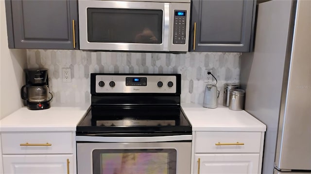 12209 Putter Green Ct, New Port Richey, FL 34654 - kitchen featuring appliances with stainless steel finishes, backsplash, light countertops, and white cabinets