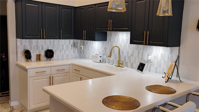 12209 Putter Green Ct, New Port Richey, FL 34654 - kitchen featuring a sink, tasteful backsplash, light countertops, and dark cabinetry