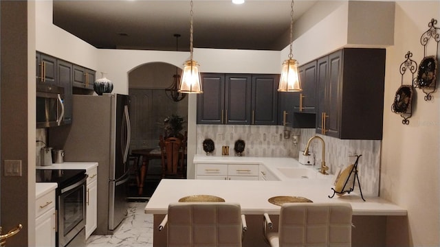 12209 Putter Green Ct, New Port Richey, FL 34654 - kitchen featuring a sink, appliances with stainless steel finishes, light countertops, backsplash, and a peninsula