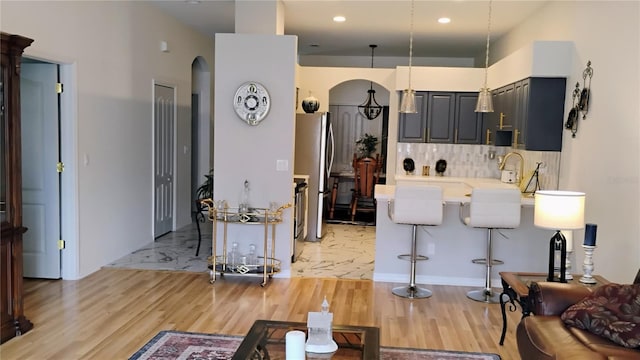 12209 Putter Green Ct, New Port Richey, FL 34654 - living area featuring arched walkways, light wood-style flooring, and recessed lighting