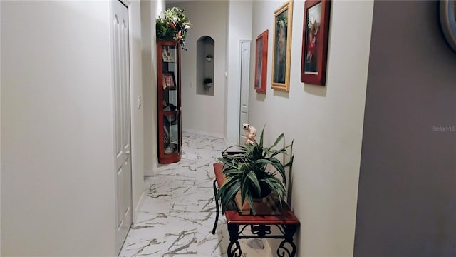 12209 Putter Green Ct, New Port Richey, FL 34654 - hall featuring marble look tiles, baseboards, and arched walkways