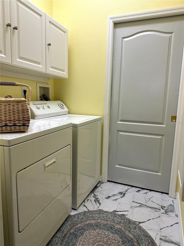 12209 Putter Green Ct, New Port Richey, FL 34654 - washroom with washer and clothes dryer, cabinet space, and light marble finish floors