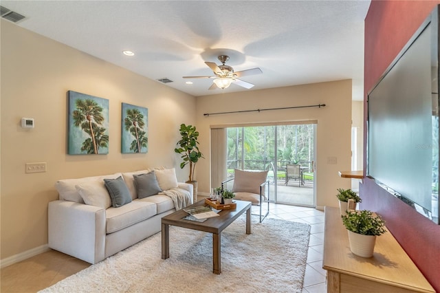 living area with visible vents, ceiling fan, and light tile patterned floors