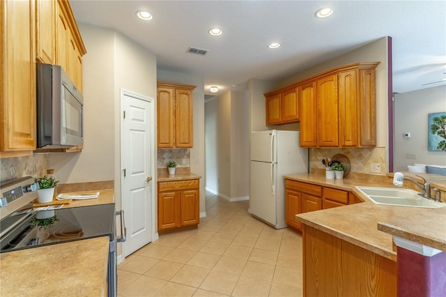 kitchen with visible vents, light countertops, electric range, freestanding refrigerator, and a sink