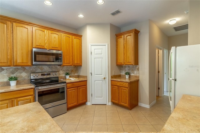 kitchen featuring appliances with stainless steel finishes, light countertops, visible vents, and light tile patterned floors