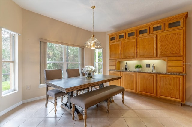 dining room featuring light tile patterned flooring, plenty of natural light, and baseboards