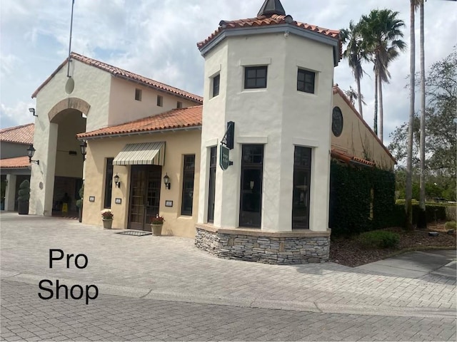 exterior space featuring a tile roof and stucco siding