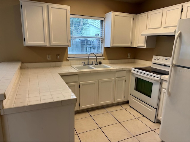 kitchen featuring white appliances, a sink, under cabinet range hood, and tile countertops